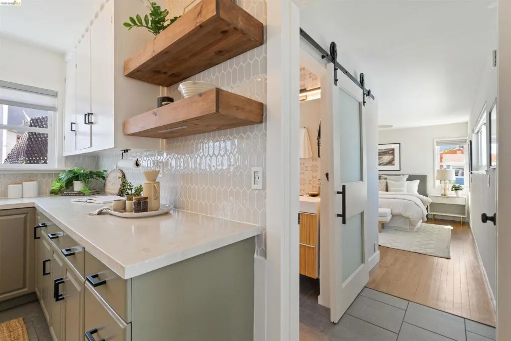 Kitchen area featuring light gray cabinetry with black hardware, white countertops, and a picket tile backsplash