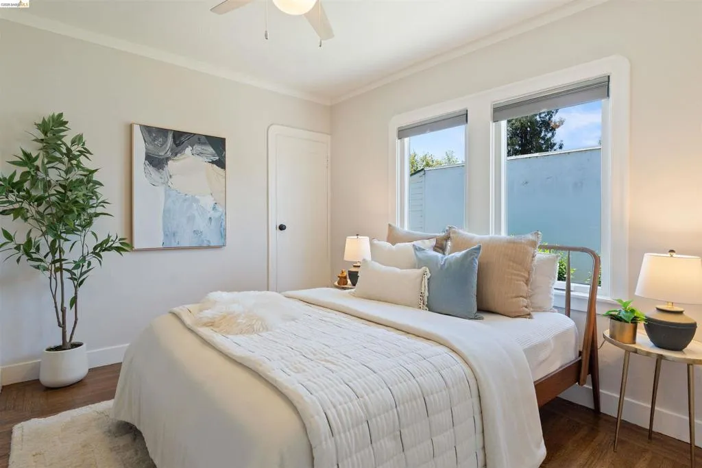 Interior bedroom has hardwood floor and a ceiling fan