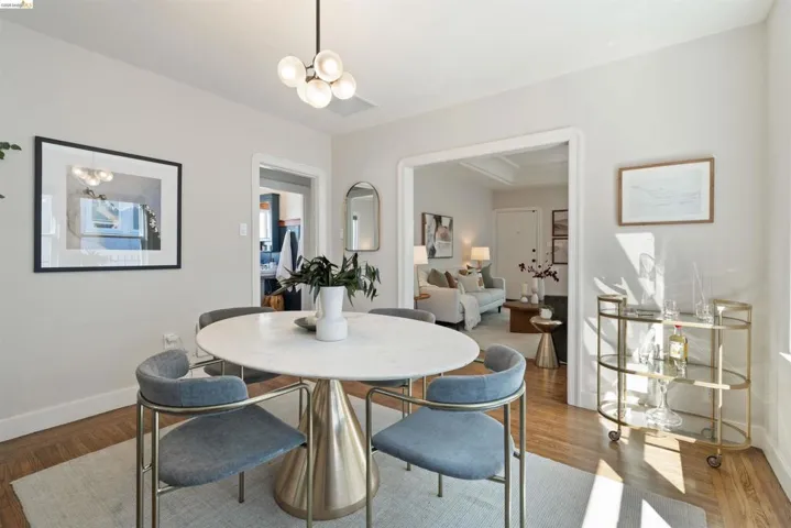 Dining area featuring wood-finish flooring and a contemporary chandelier