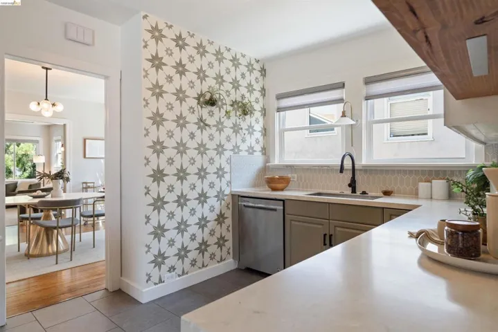 Kitchen featuring a stainless steel dishwasher, modern black faucet, and light-toned hexagonal tile backsplash