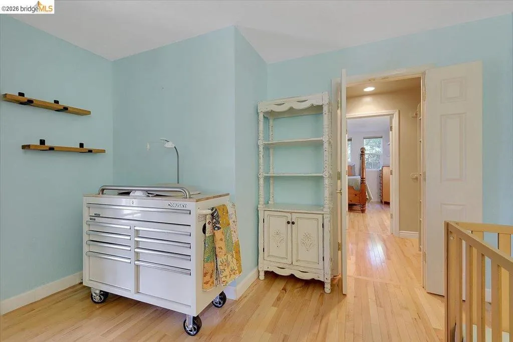 Light-toned wood-finish flooring provides a bright foundation for this room, featuring light blue wall paint and white trim