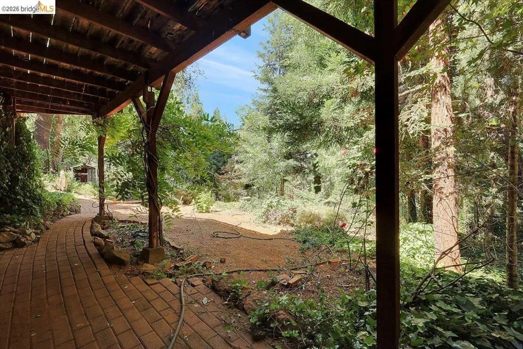 Covered outdoor pathway featuring a wood beam ceiling and structural posts
