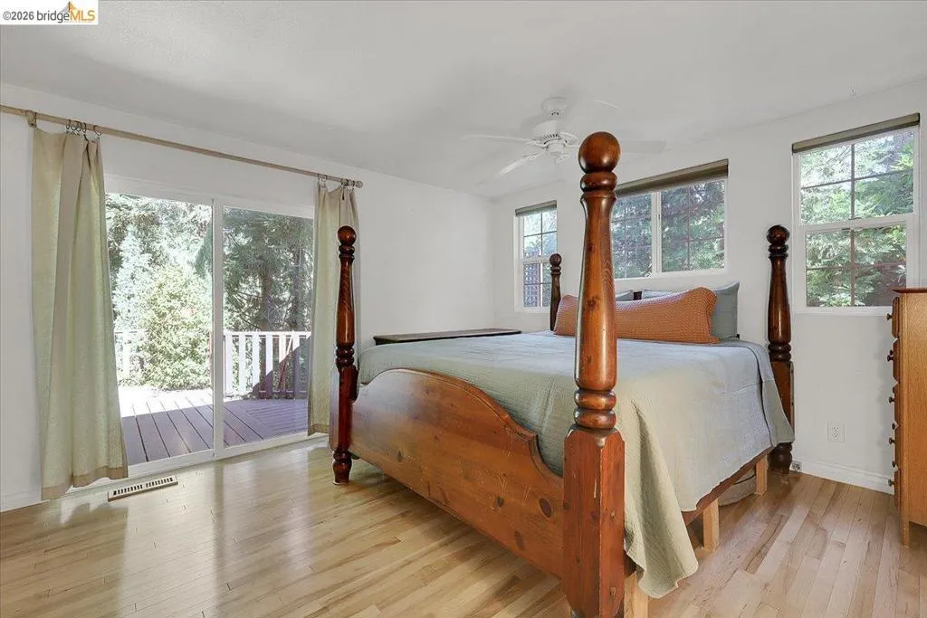 Spacious room featuring wood-finish flooring and a white ceiling fan
