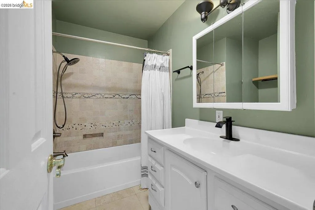 White vanity with integrated sink, black matte faucet, and matching cabinet hardware