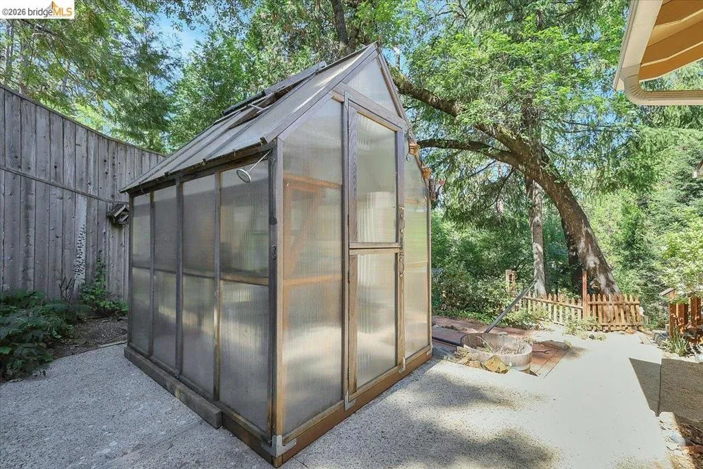 Freestanding greenhouse with translucent panels and a hinged entry door