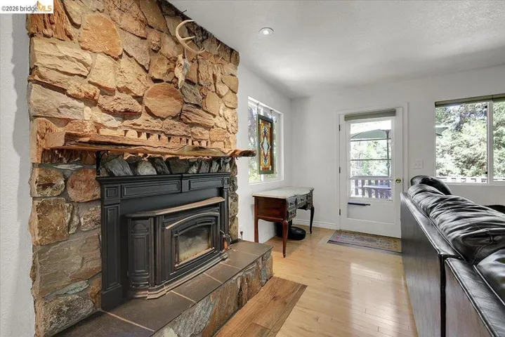 Stone-clad fireplace featuring a wood-burning insert and slate hearth