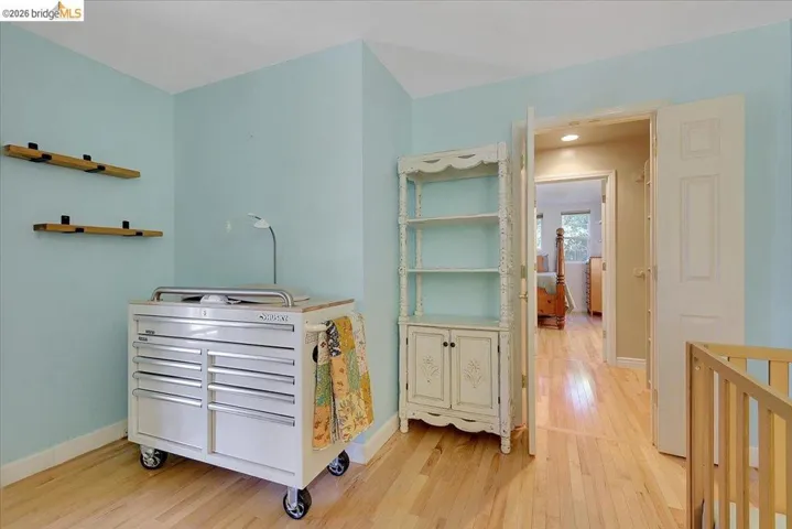 Light-toned wood-finish flooring provides a bright foundation for this room, featuring light blue wall paint and white trim