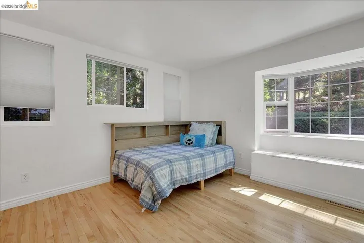Bright room featuring light wood-finish flooring, white baseboards, and a large bay window with an integrated window seat
