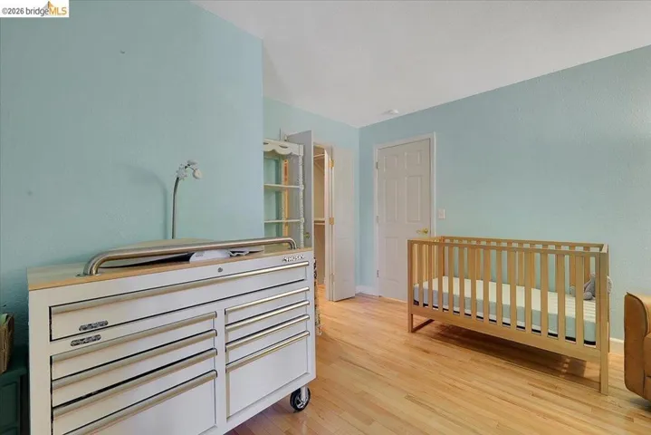 Light-filled room featuring wood-finish flooring, two panel doors, and a closet with built-in shelving