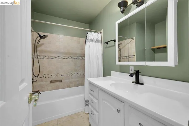 White vanity with integrated sink, black matte faucet, and matching cabinet hardware