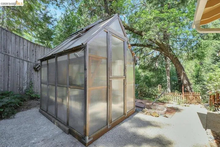 Freestanding greenhouse with translucent panels and a hinged entry door