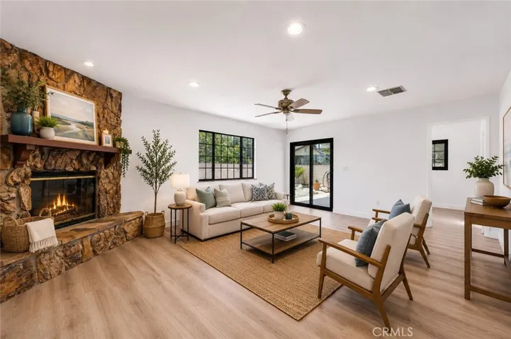 Spacious living room with stone fireplace and luxury vinyl flooring.