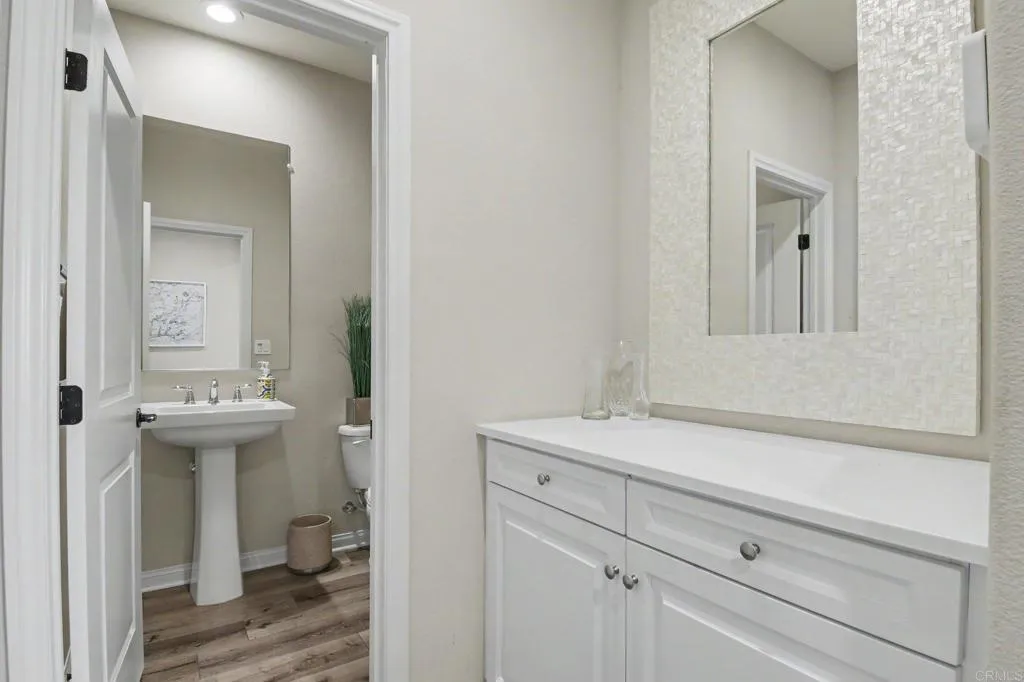 Guest 1/2 bath, just off garage entry and flanked by built-in storage niche