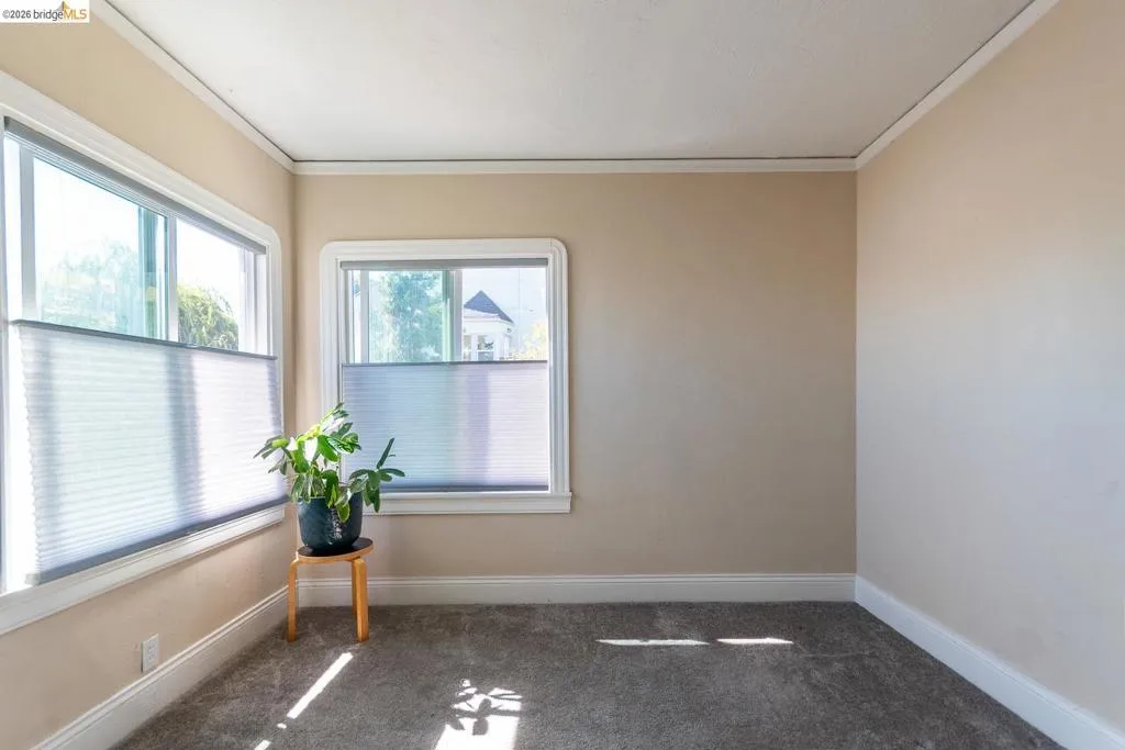 Bright interior room featuring two windows with white trim and integrated cellular shades