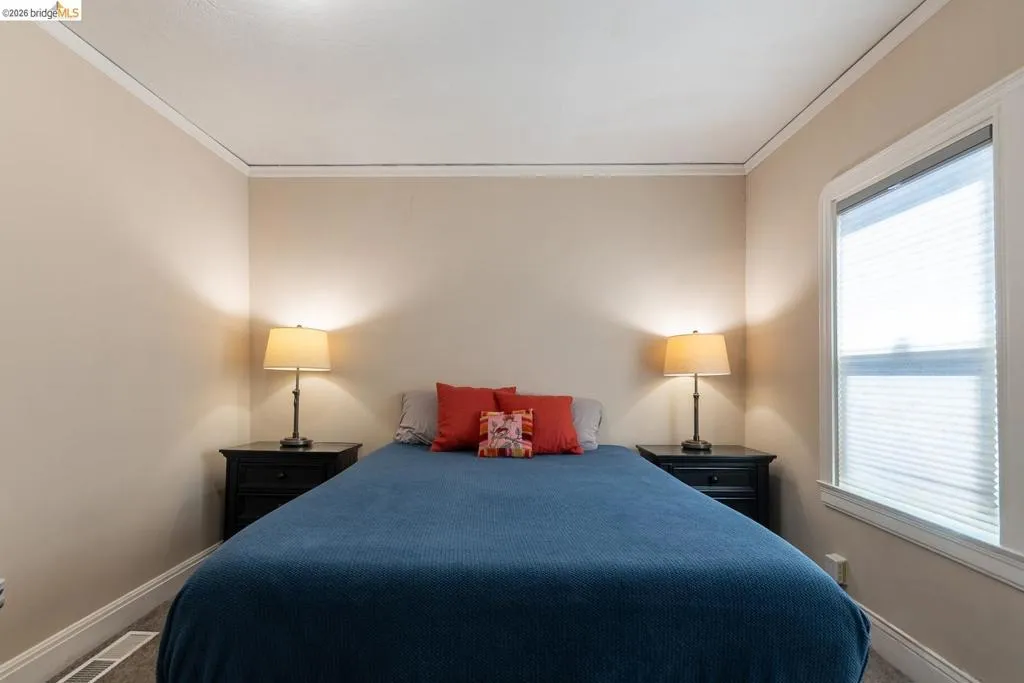 Bedroom featuring neutral wall paint, white crown molding, and baseboards