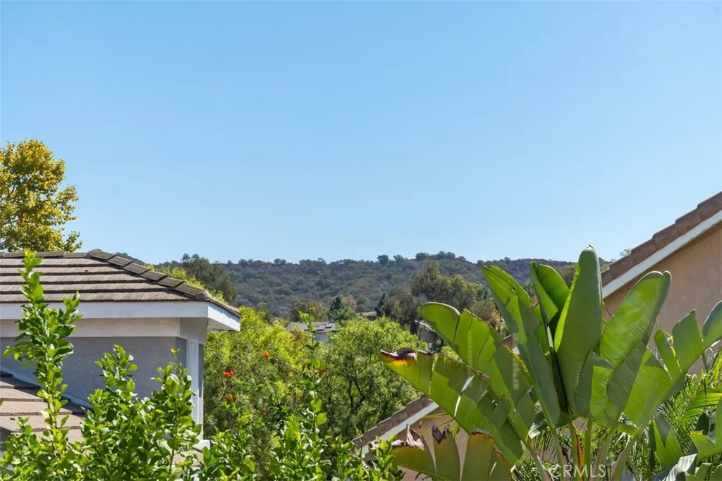 View: Elevated outlook across mature landscaping and surrounding hills, adding a pleasant scenic backdrop from the upper level.