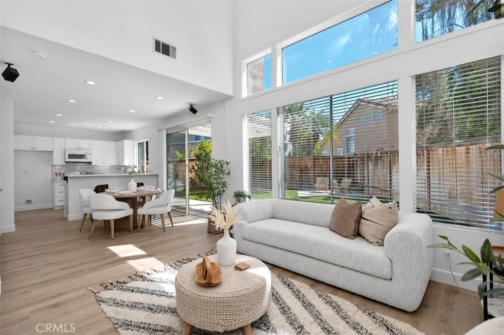 Family Room / Dining Area: Expansive windows, high ceilings, and an open connection to the dining area and kitchen create a bright gathering space with views toward the backyard.