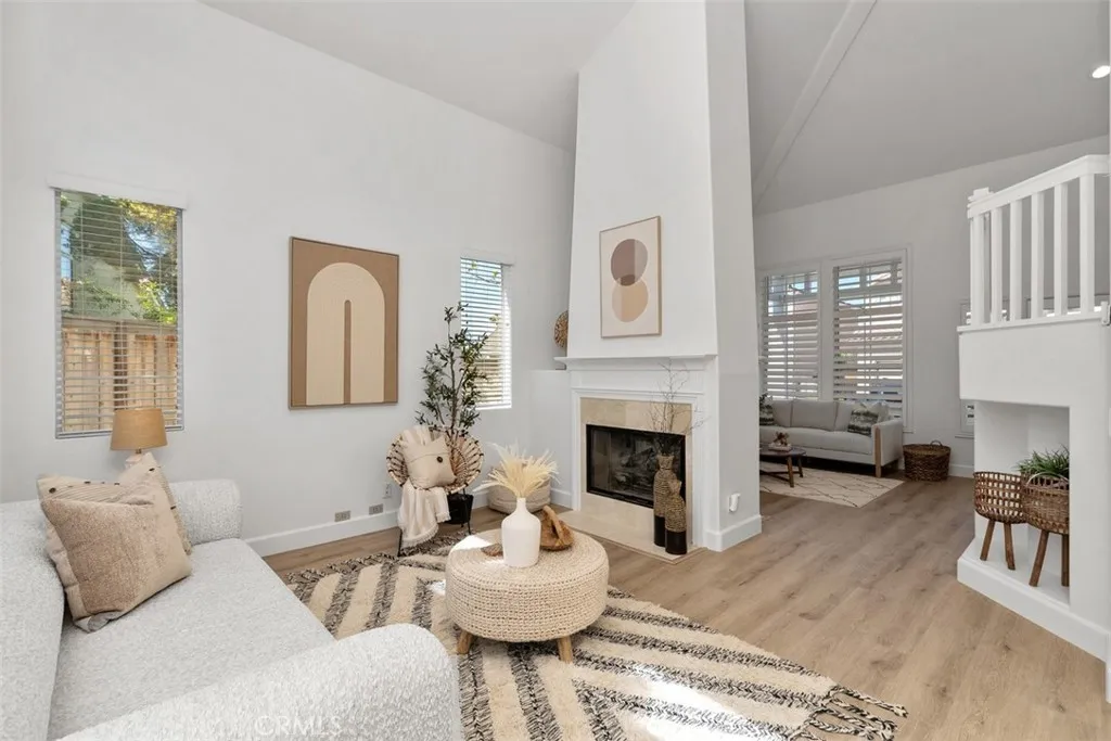 Living Room: Open sightlines connect the fireplace-centered living space with the adjacent sitting area and staircase, creating a spacious, cohesive layout.