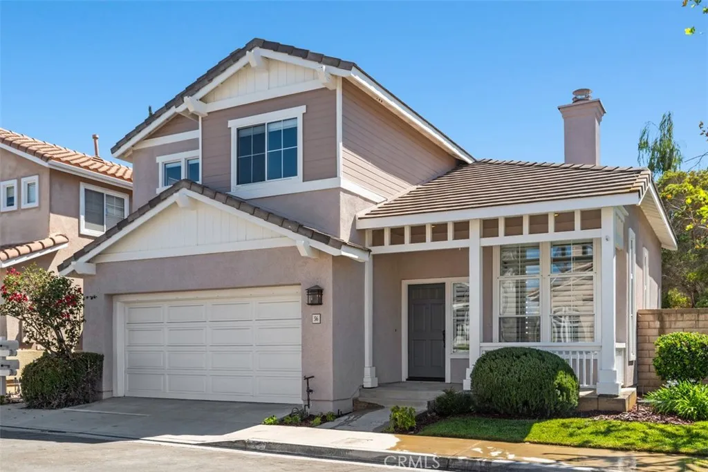 Exterior: Two-story home with an attached two-car garage, covered entry, contrasting exterior finishes, and neatly maintained front landscaping.