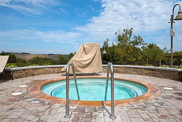 Community Spa: Circular spa with surrounding paver deck and open hillside views offers an additional outdoor amenity.