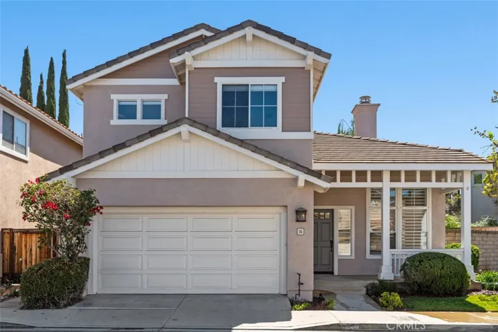 Exterior: Front elevation highlights the attached garage, covered porch, multi-level rooflines, and a welcoming entry framed by mature landscaping.