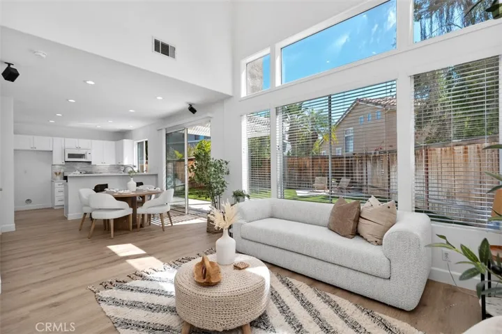 Family Room / Dining Area: Expansive windows, high ceilings, and an open connection to the dining area and kitchen create a bright gathering space with views toward the backyard.