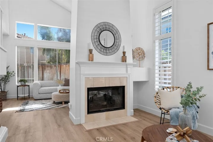 Living Room / Fireplace: The fireplace serves as a central focal point, complemented by a classic mantel, tile surround, and nearby windows that brighten the space.