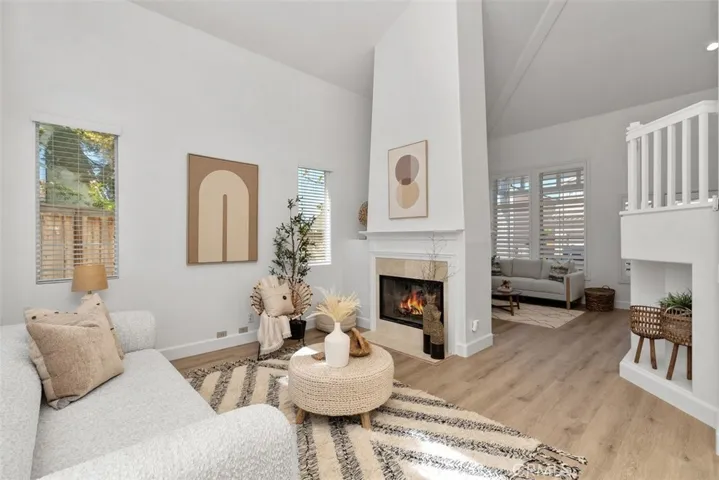 Living Room / Fireplace: A closer view highlights the fireplace with tile surround, tall surrounding walls, and nearby windows that brighten the room.