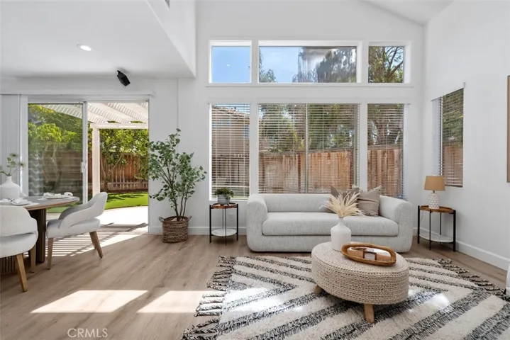 Sitting Area / Dining Area: Expansive windows and a sliding glass door connect this light-filled space to the backyard patio, creating easy indoor-outdoor flow.