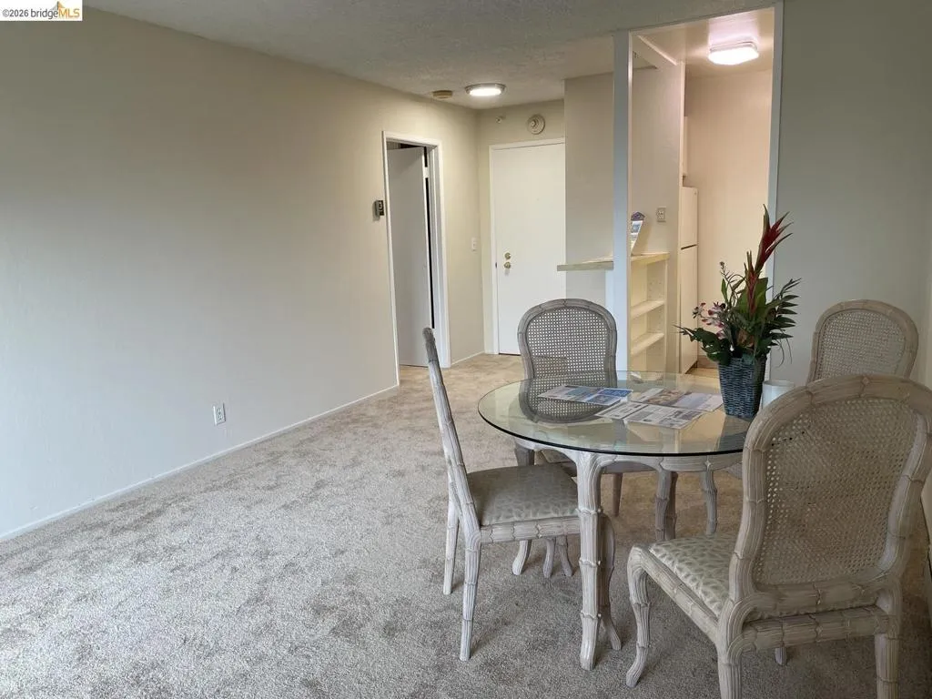 Carpeted interior with light-colored walls, featuring a dining area with a glass-top table