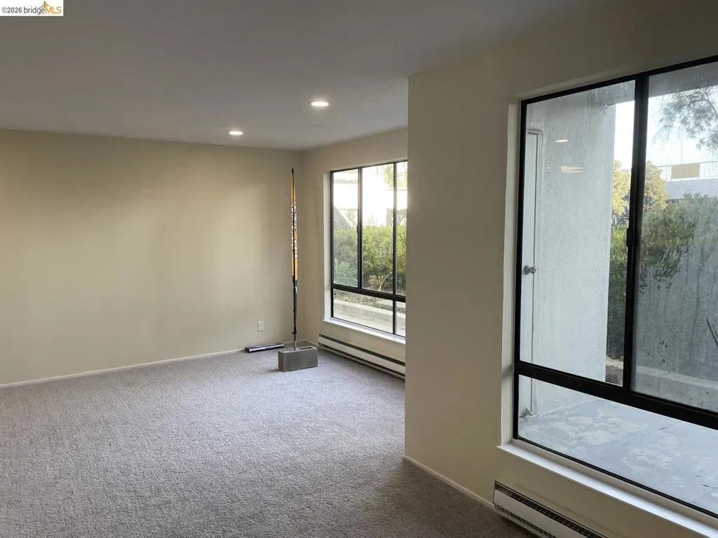 Spacious room featuring neutral carpeting and light-toned walls