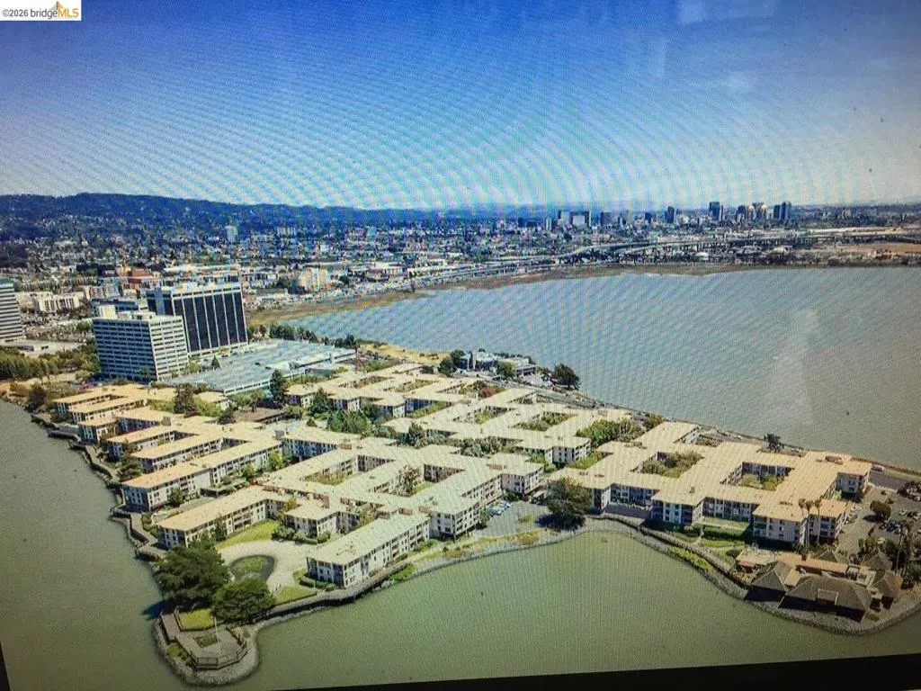 Waterfront residential community featuring multi-story buildings with flat roofs and landscaped courtyards