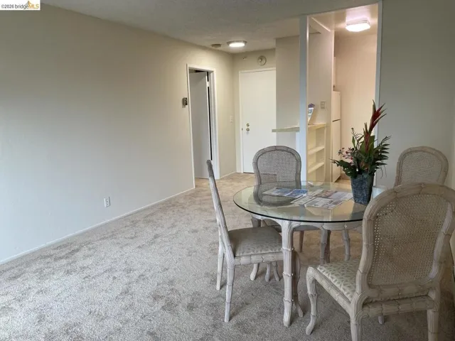 Carpeted interior with light-colored walls, featuring a dining area with a glass-top table