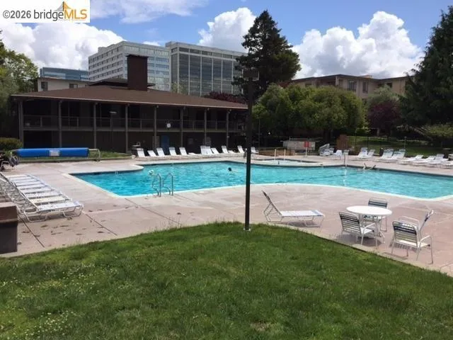 Expansive outdoor pool area featuring a large swimming pool, an adjacent smaller pool, and a surrounding concrete deck