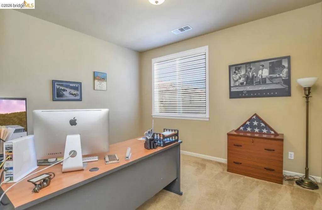 Room with light beige wall paint, carpet flooring, and a single window with horizontal blinds