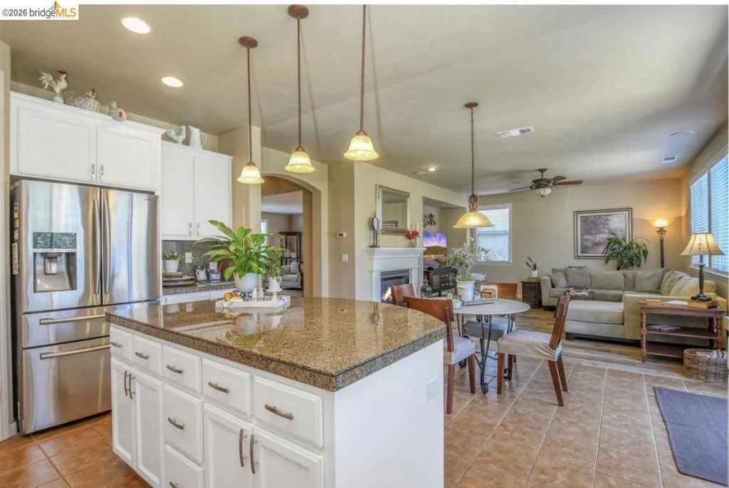 Kitchen island with a granite-style countertop and pendant lighting