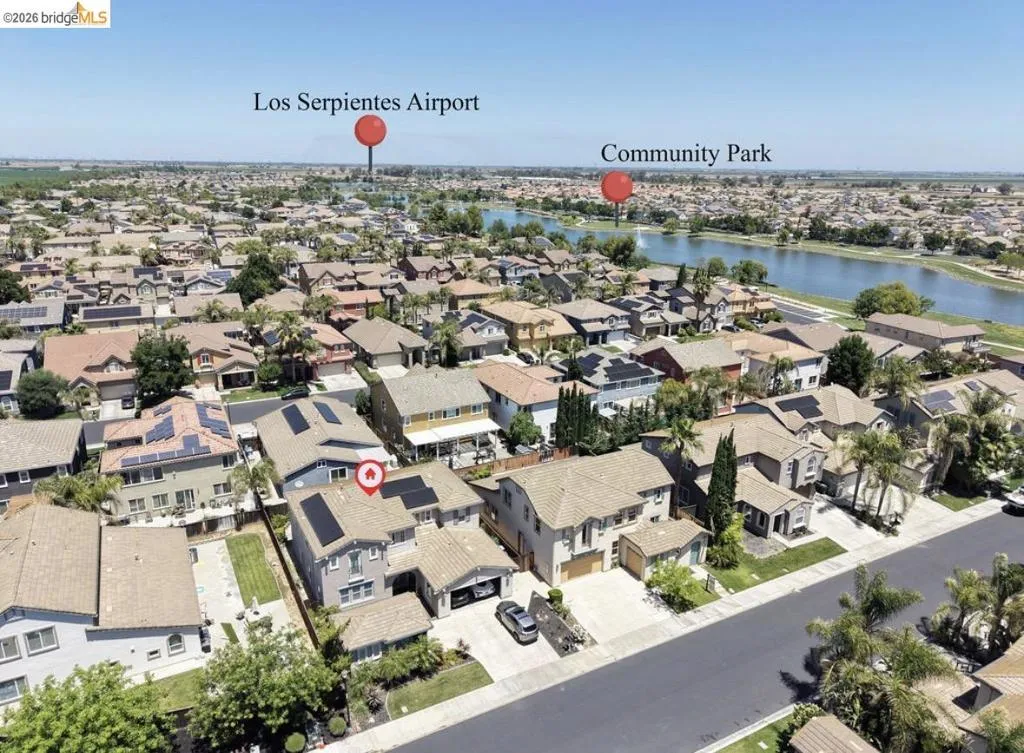 Aerial perspective showcasing a residential neighborhood with a prominent water feature
