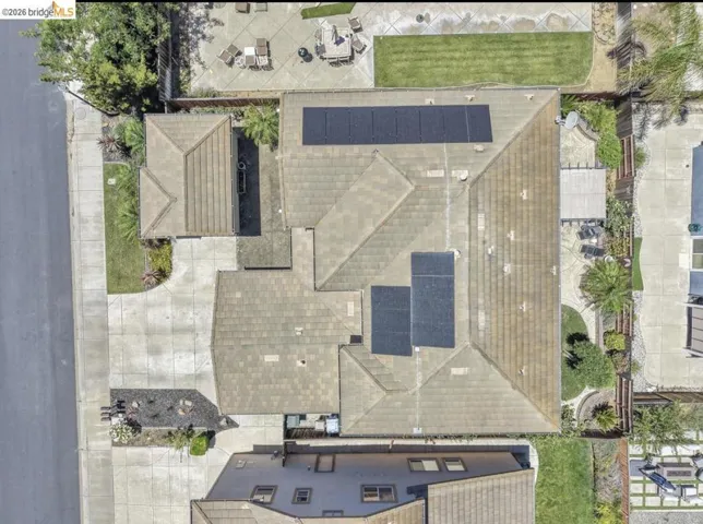 Aerial perspective showcasing a property with a multi-gabled roofline and integrated solar panels