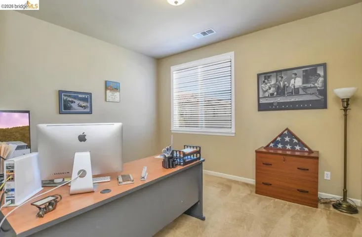 Room with light beige wall paint, carpet flooring, and a single window with horizontal blinds