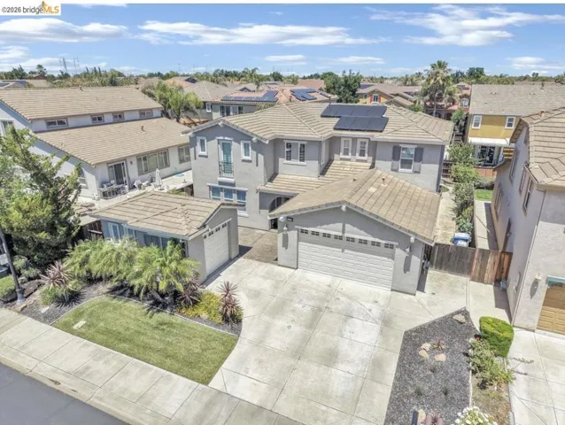 Two-story residence featuring a tile roof and solar panels
