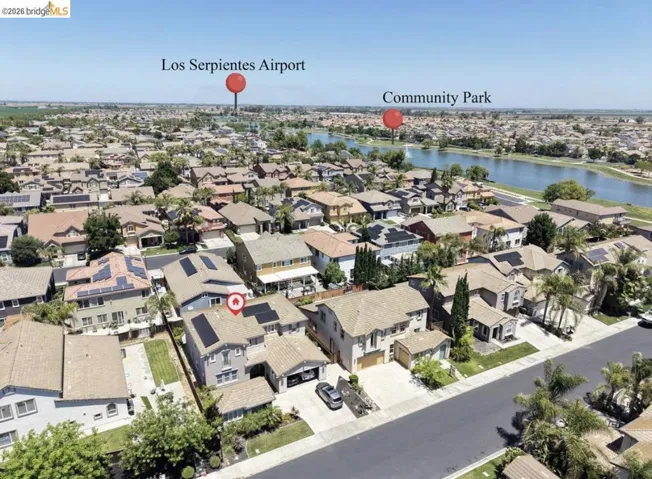 Aerial perspective showcasing a residential neighborhood with a prominent water feature