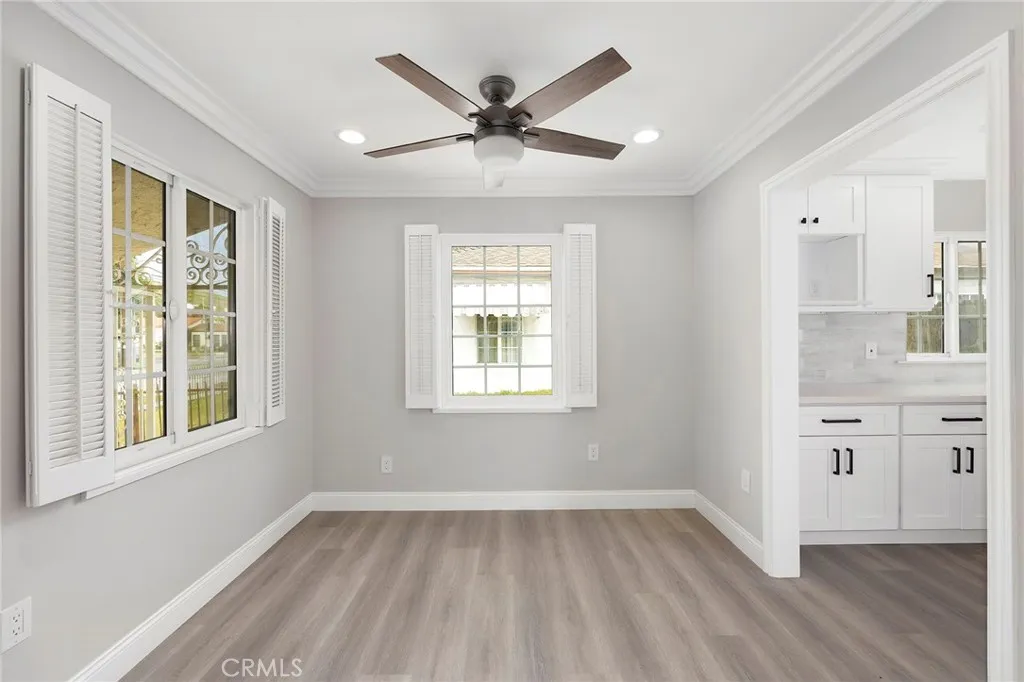 Dining room with ceiling fan and newer windows, adjacent to the fully remodeled kitchen.