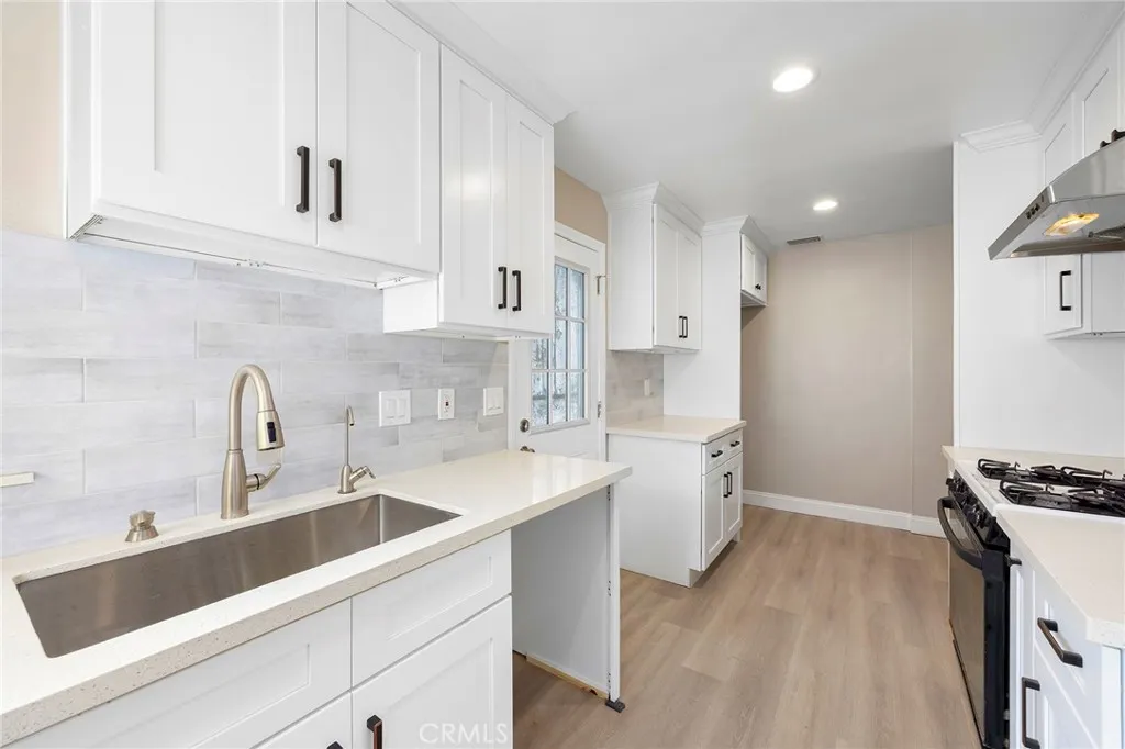 Brand new kitchen from floor to ceiling with tons of cabinets and quarts counter top and tile back splash.