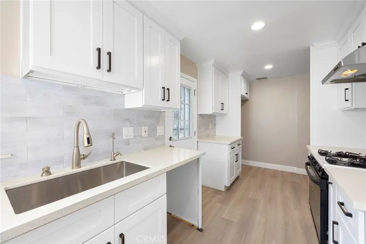 Brand new kitchen from floor to ceiling with tons of cabinets and quarts counter top and tile back splash.
