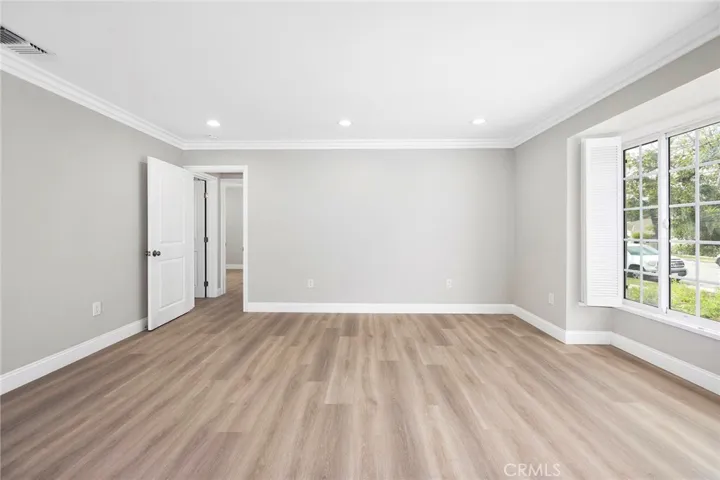 Living room with brand-new hard wood floor, freshly painted wall and recessed ceiling light.