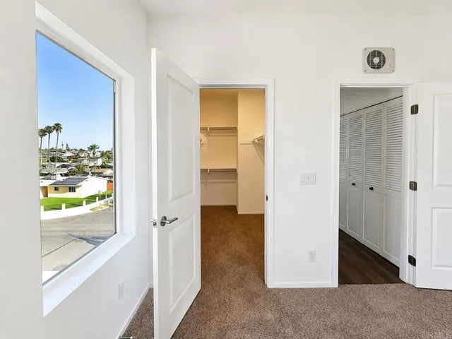 Large primary bedroom closet with ample hanging and storage space.
