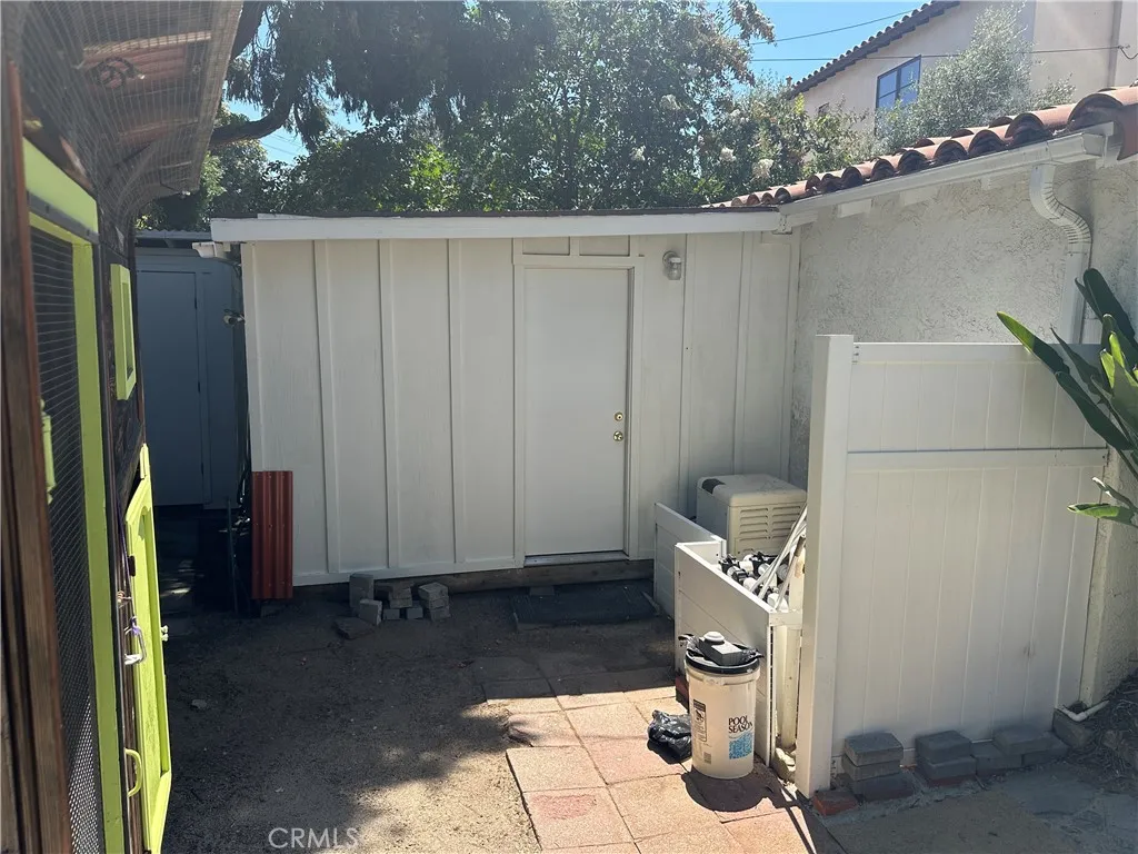 Shed or workshop attached to garage, chicken coop on the left, pool filter equipment on the right