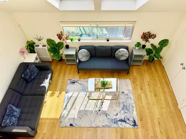 Living area with wood-finish flooring and sloped ceilings