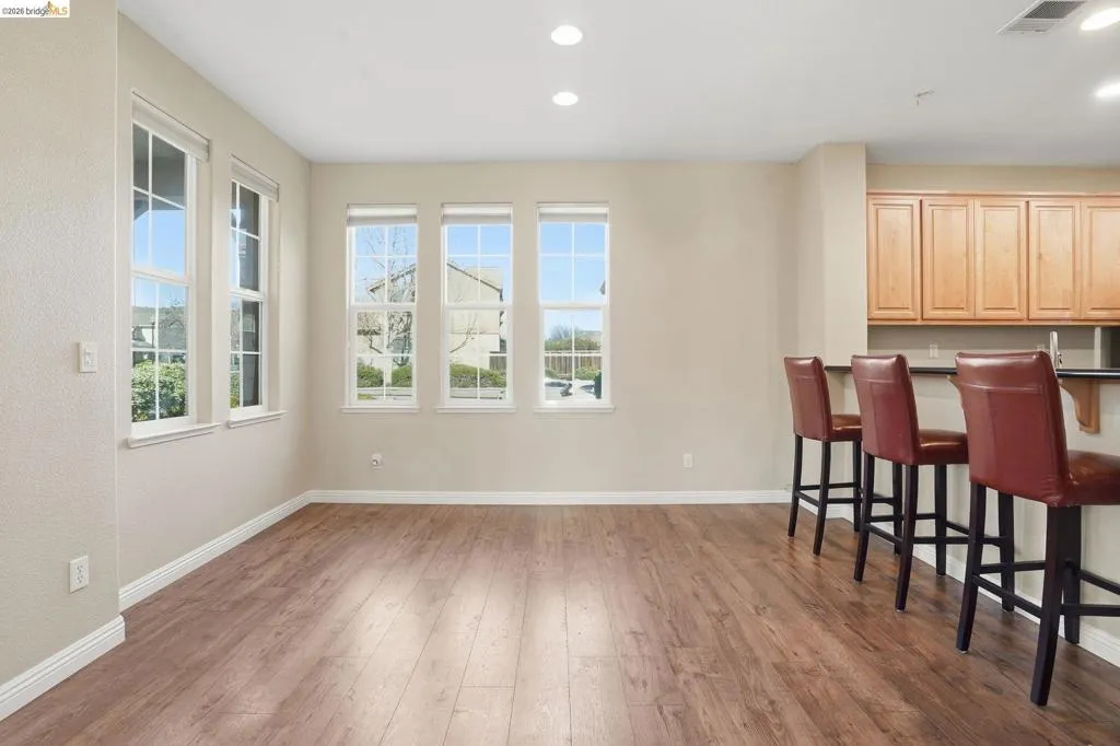 Bar area featuring light wood-style floors, recessed lighting, and light wood finish cabinets