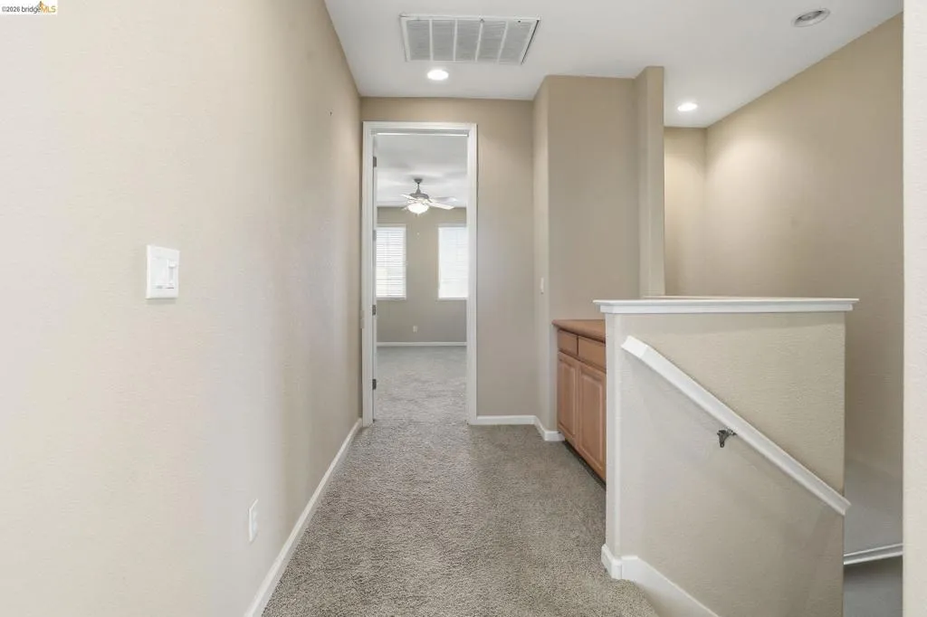 Hall featuring light colored carpet, an upstairs landing, and recessed lighting